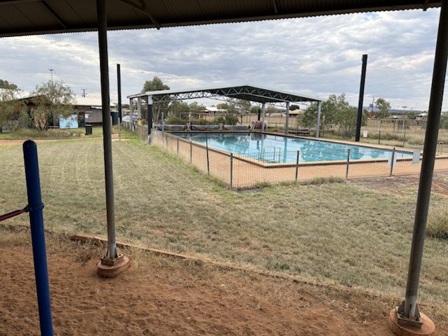 A remote community pool viewed from the shade